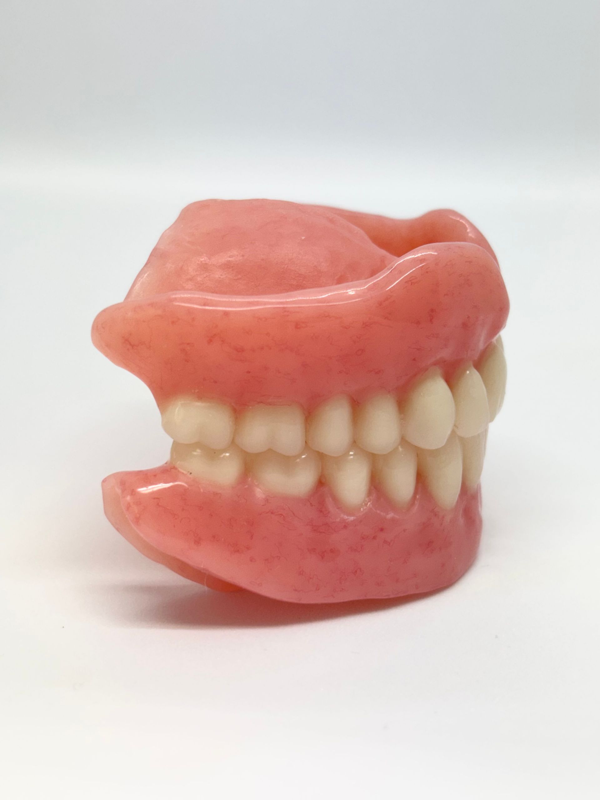Pink Dentures With White Teeth on a Plain White Background — Precise Dentures in Berserker, QLD