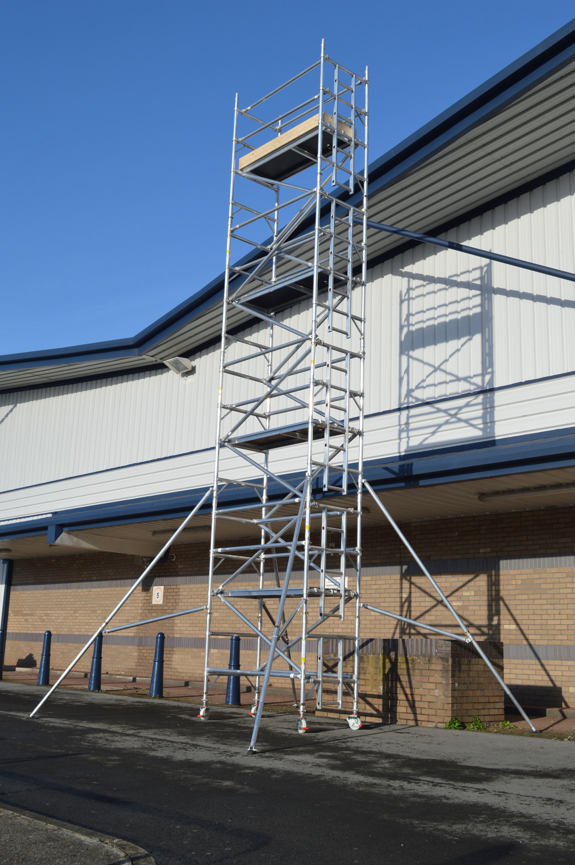 A scaffolding tower is sitting in front of a building.