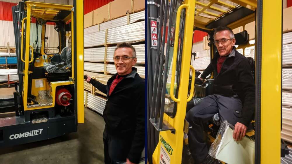 Two men are standing next to a forklift in a warehouse.