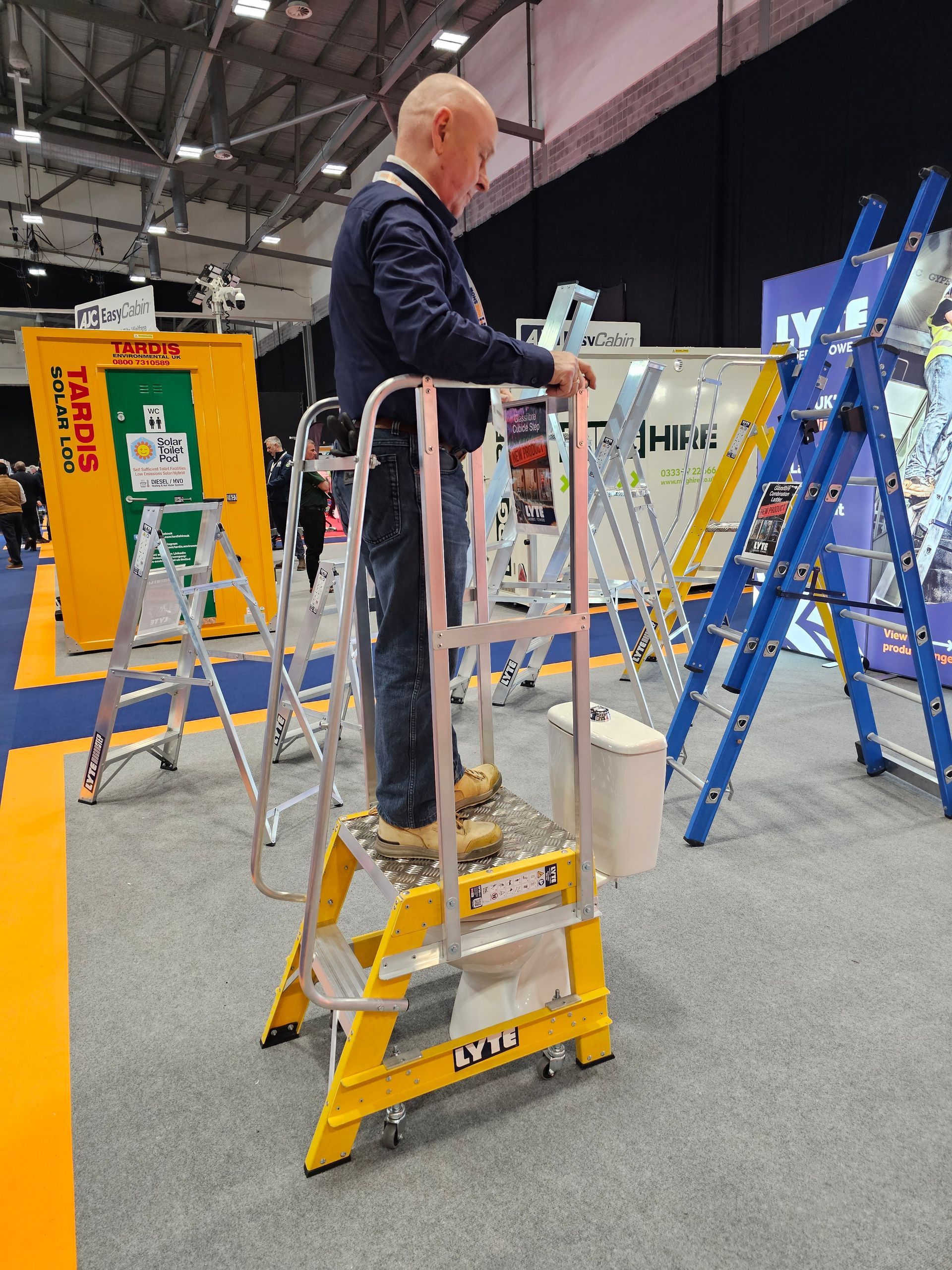 Cubicle Platform Step demonstrated over a toilet  at the Executive Hire Show