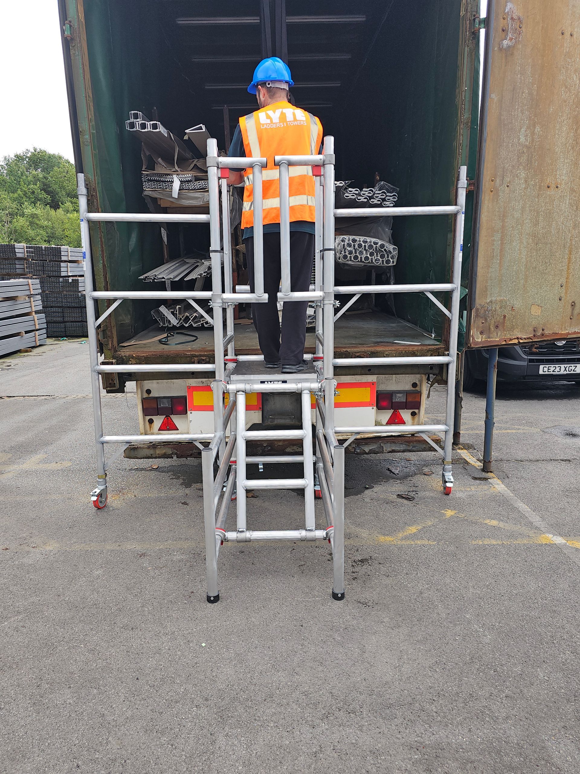 An aluminium podium step with added side barriers for access to lorries