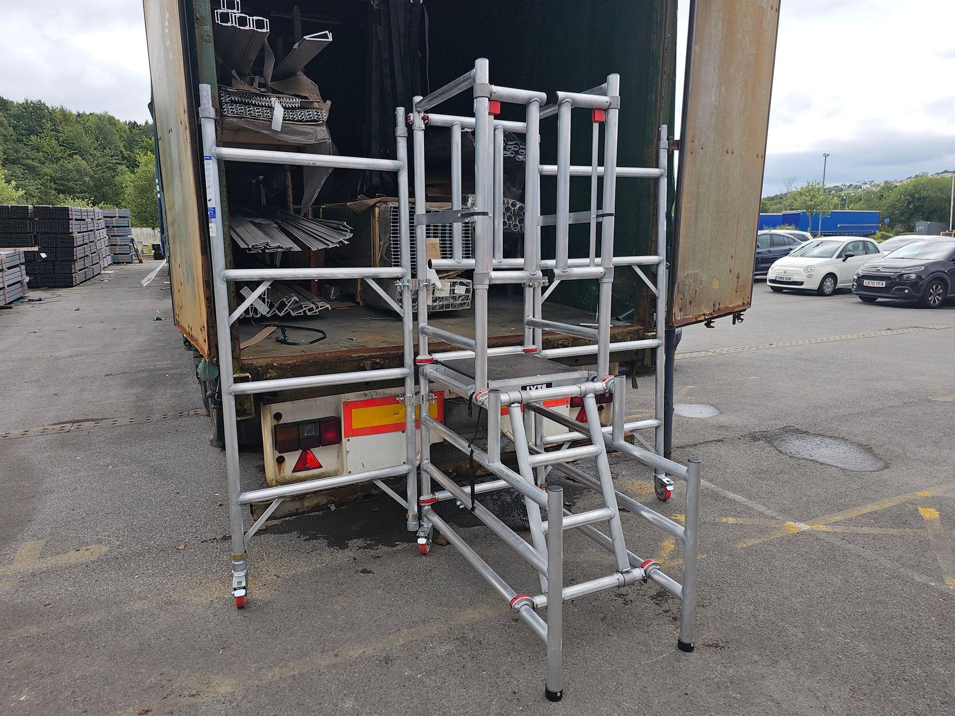 An aluminium podium step with added side barriers for access to lorries