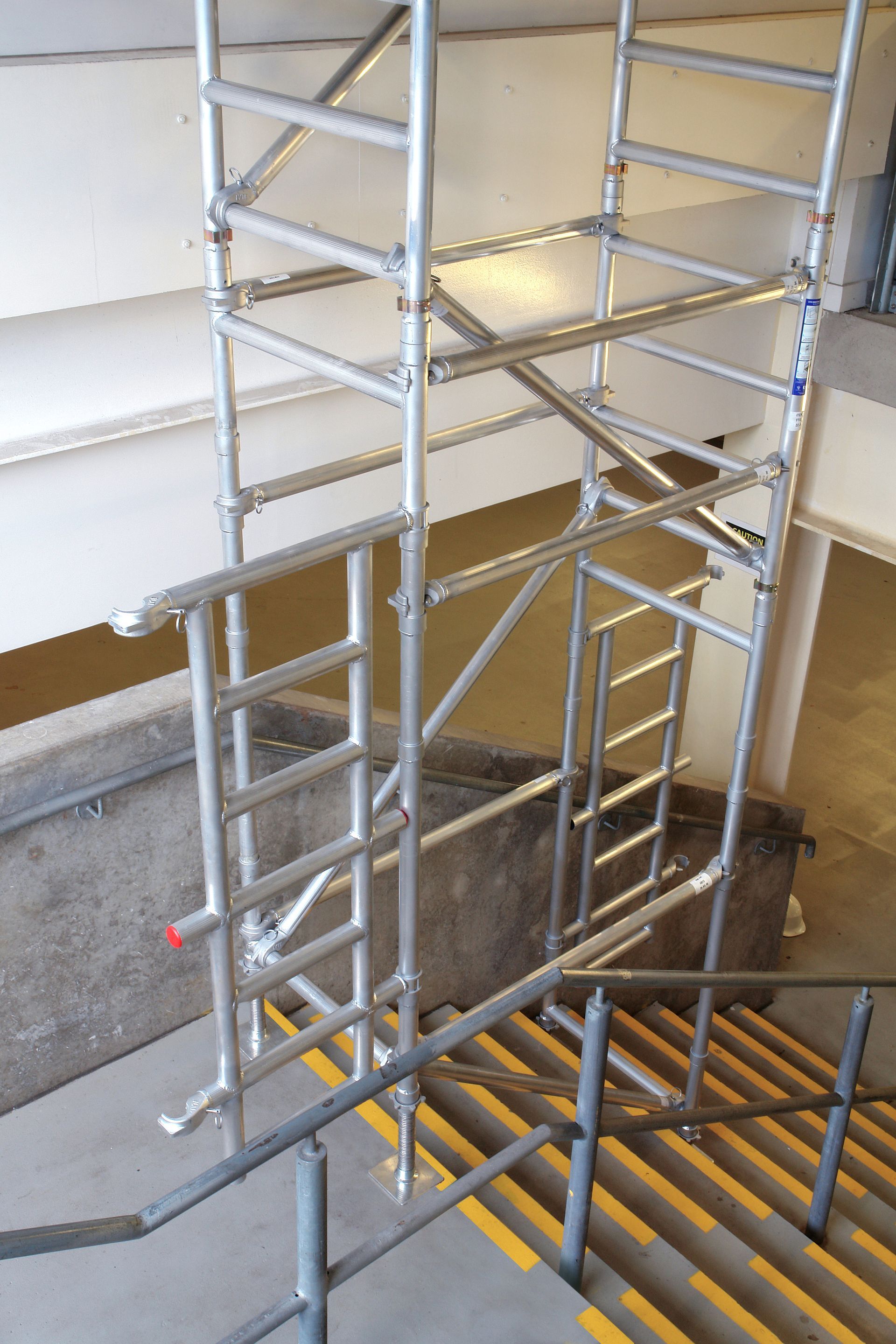 A scaffolding is attached to the side of a set of stairs.