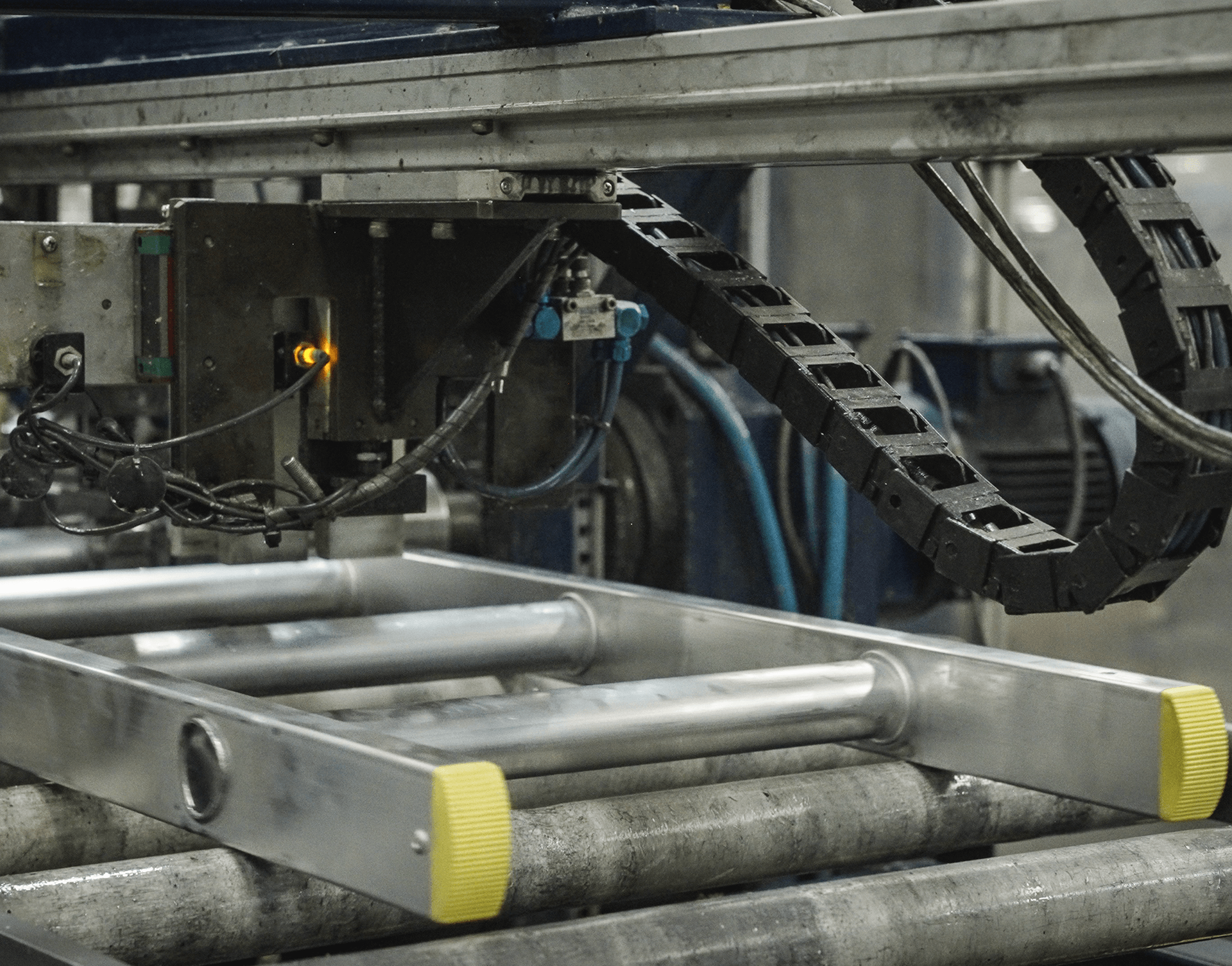 A ladder is sitting on top of a conveyor belt in a factory.