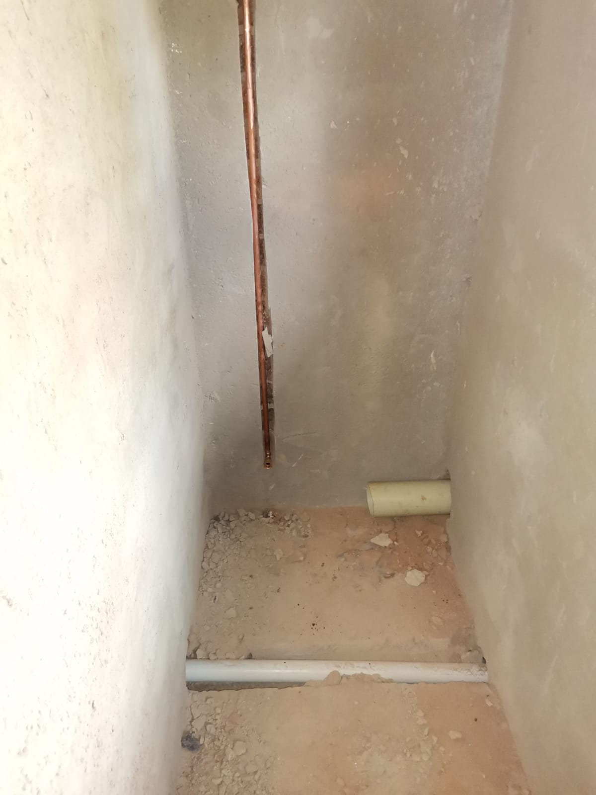 Newly installed copper plumbing pipes running through wall