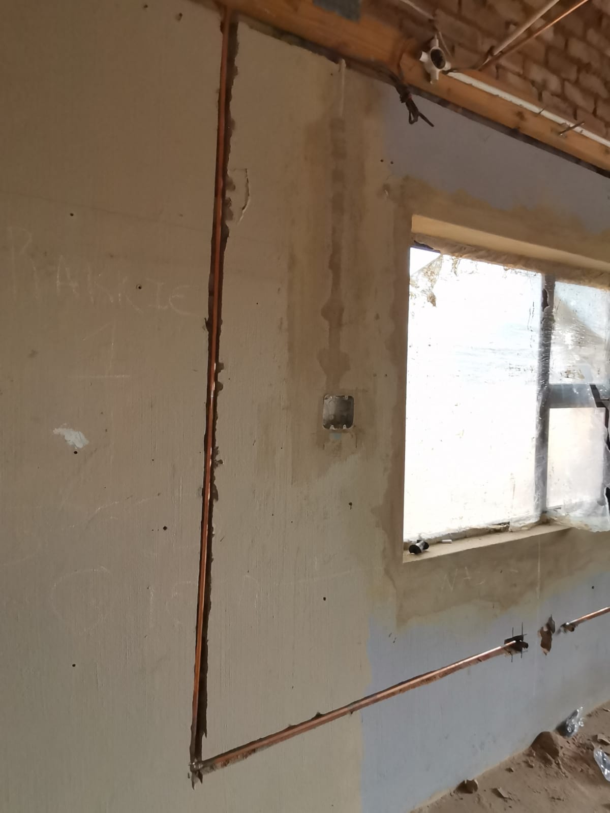 Newly installed copper plumbing pipes running through wall