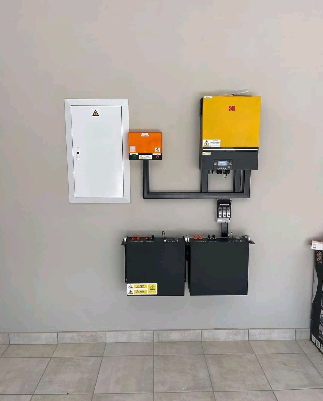 Inverter connected to batteries and control panel next to electrical distribution board