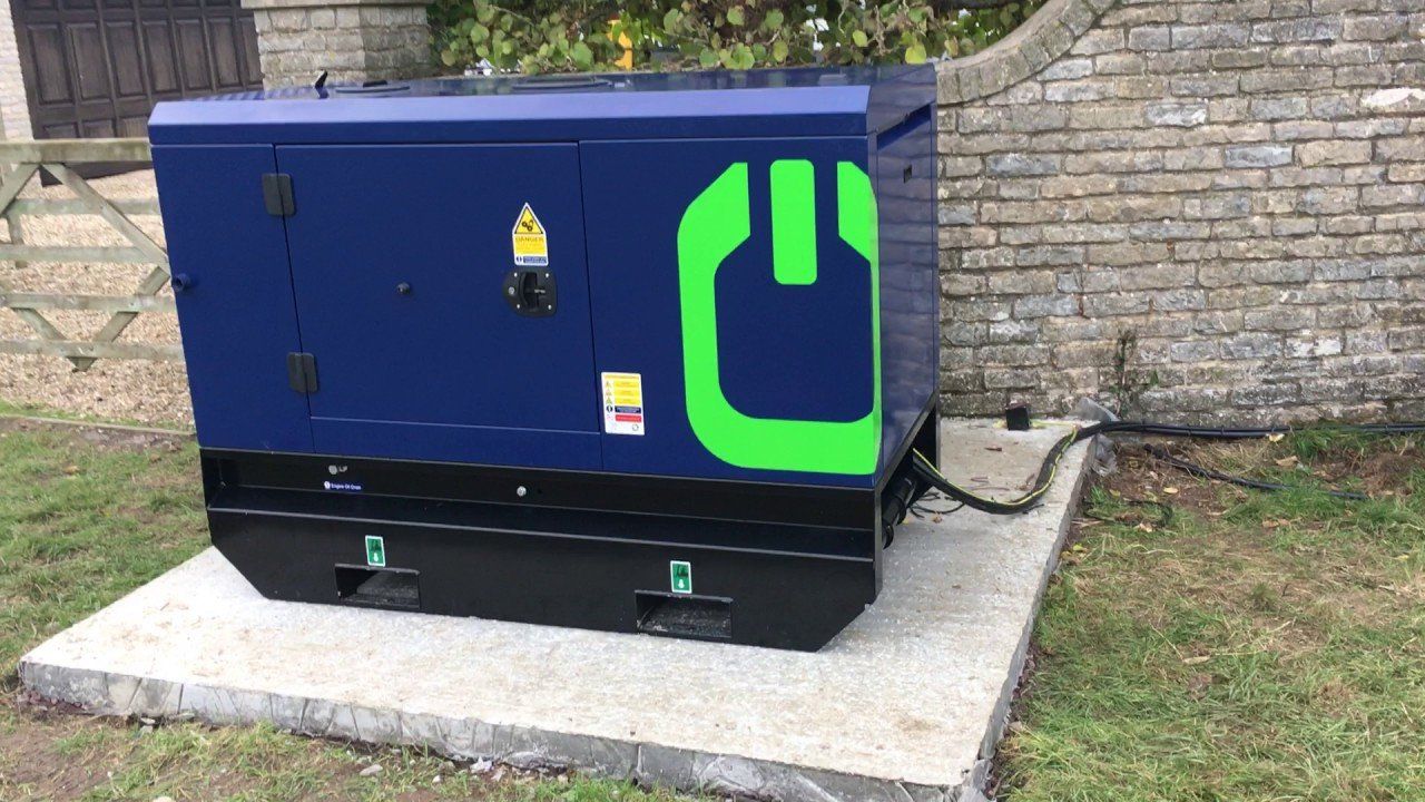 Commercial diesel electric generator standing outside on cement block