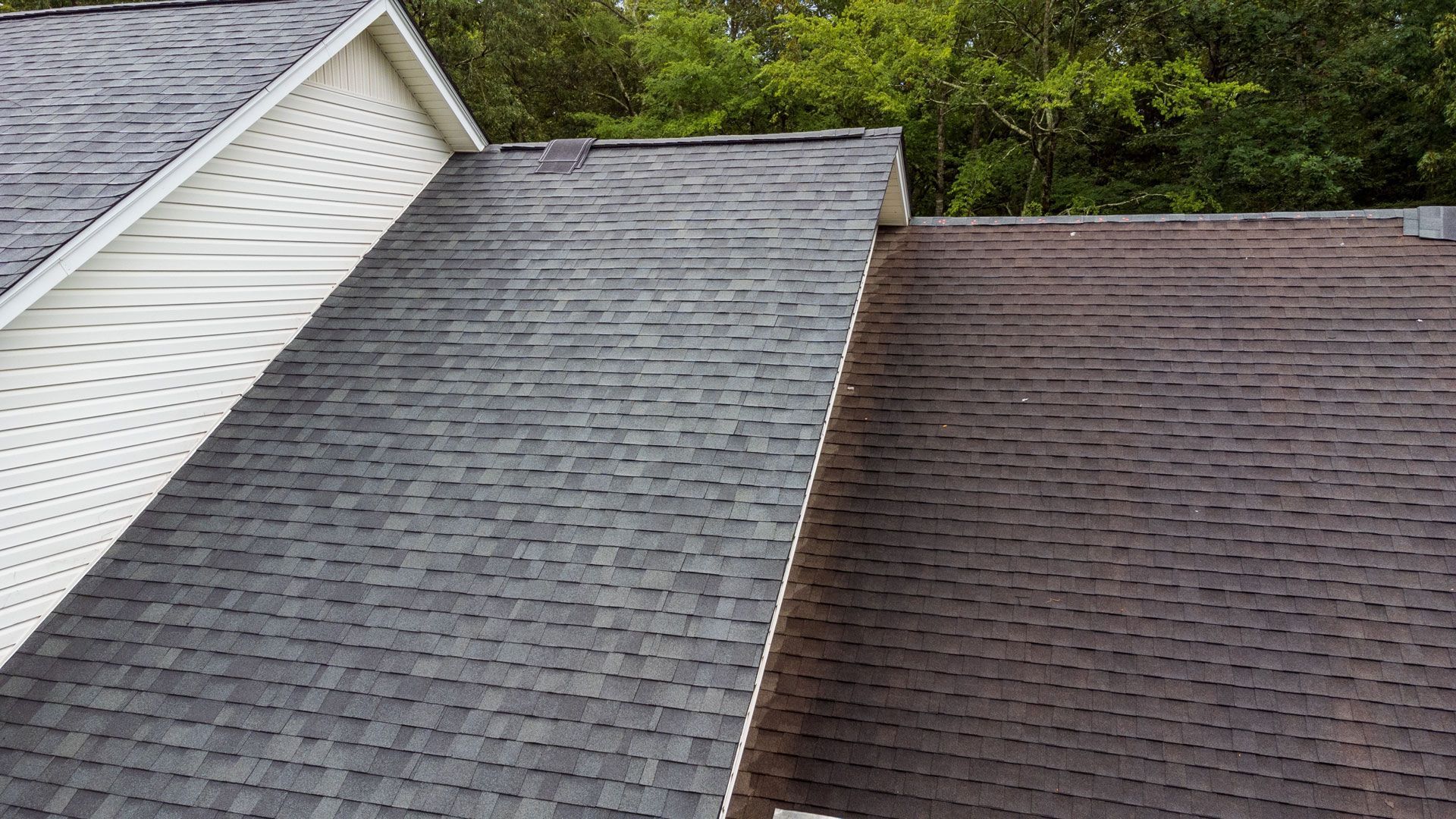 Close-up of a house roof, showing gray and brown shingles.
