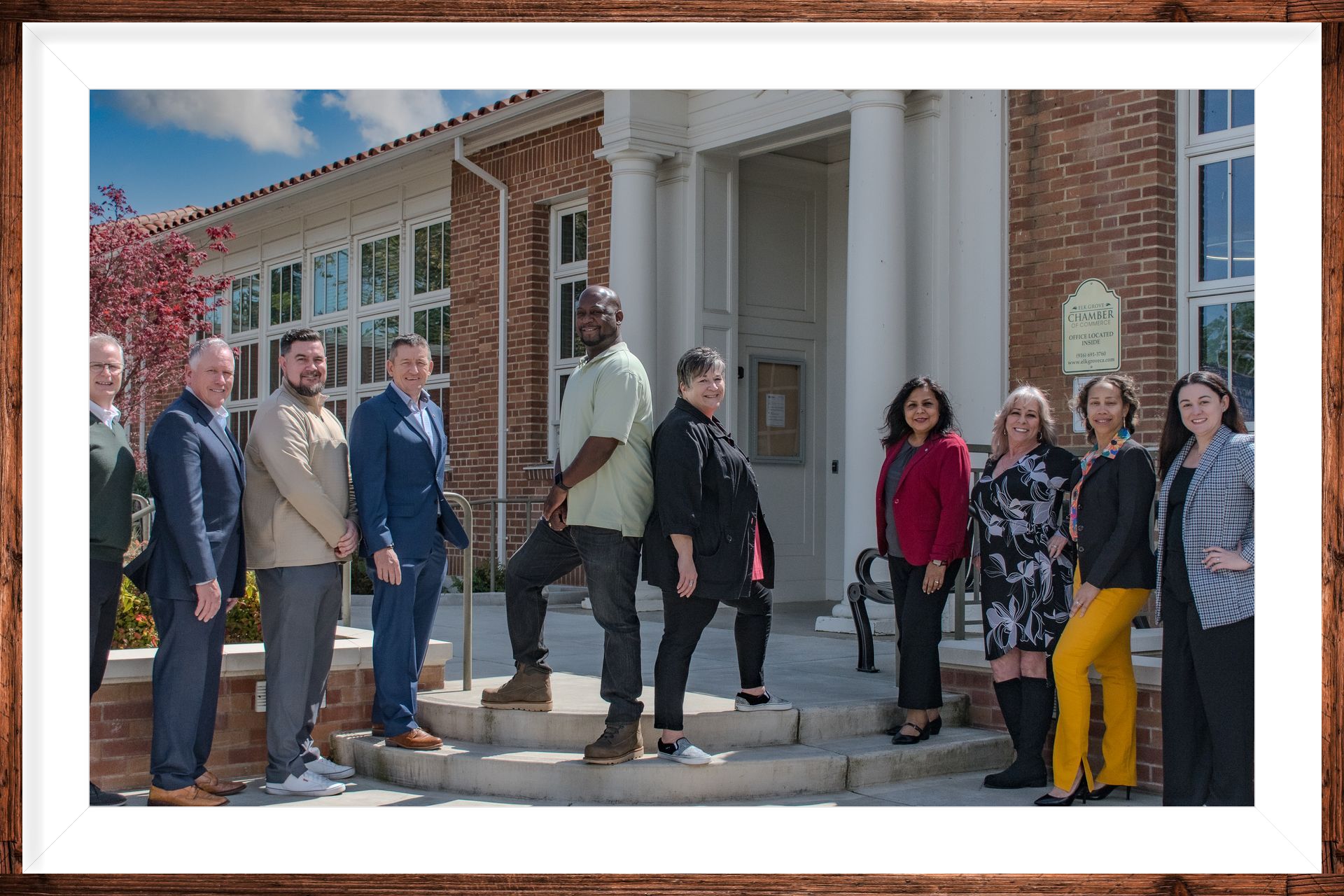 A group of people are posing for a picture in front of a building.
