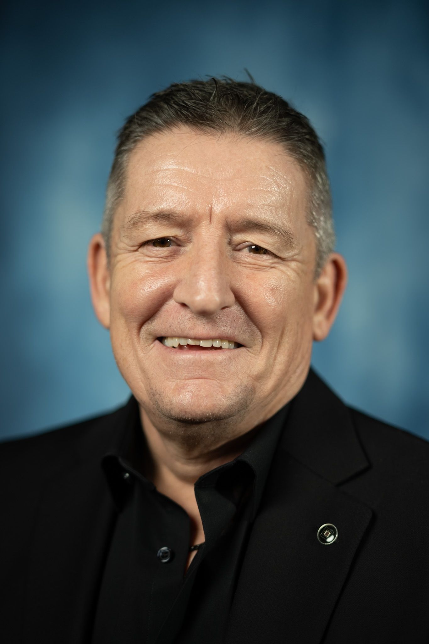 A man in a suit and tie is smiling for the camera.