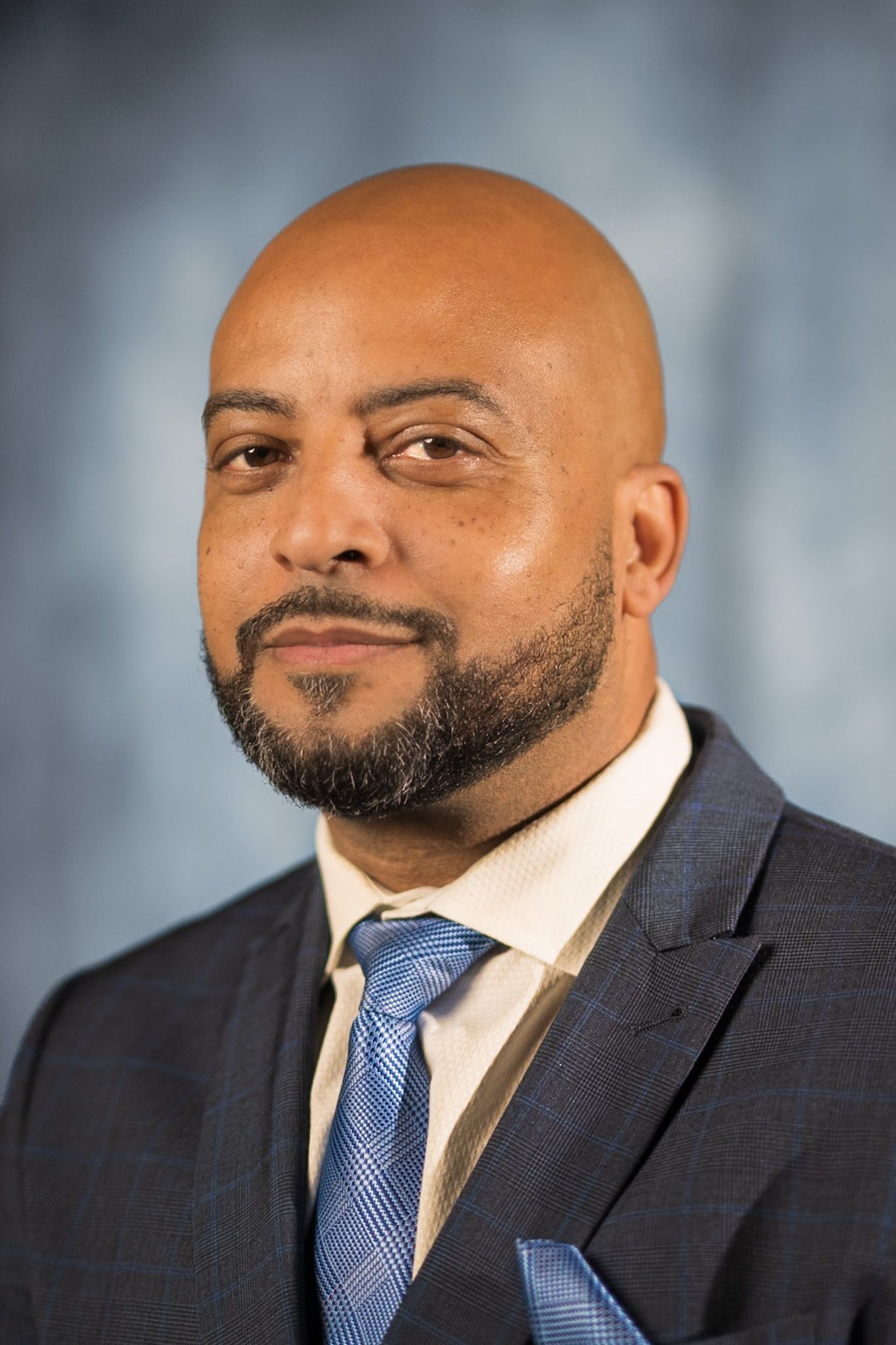 A man in a suit and tie is smiling for the camera.