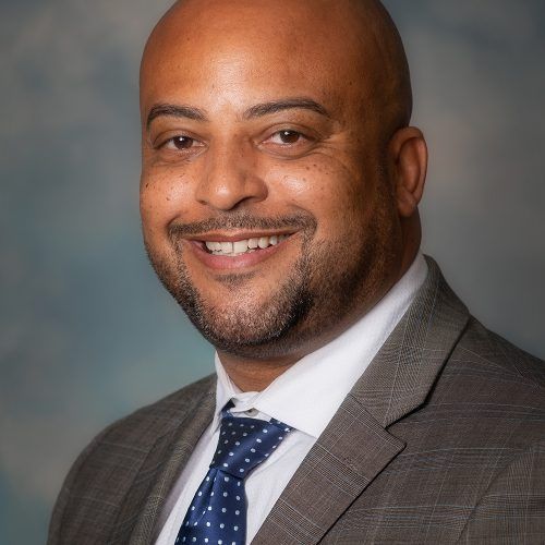 A man in a suit and tie is smiling for the camera.