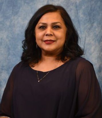 A woman in a blue shirt is posing for a picture