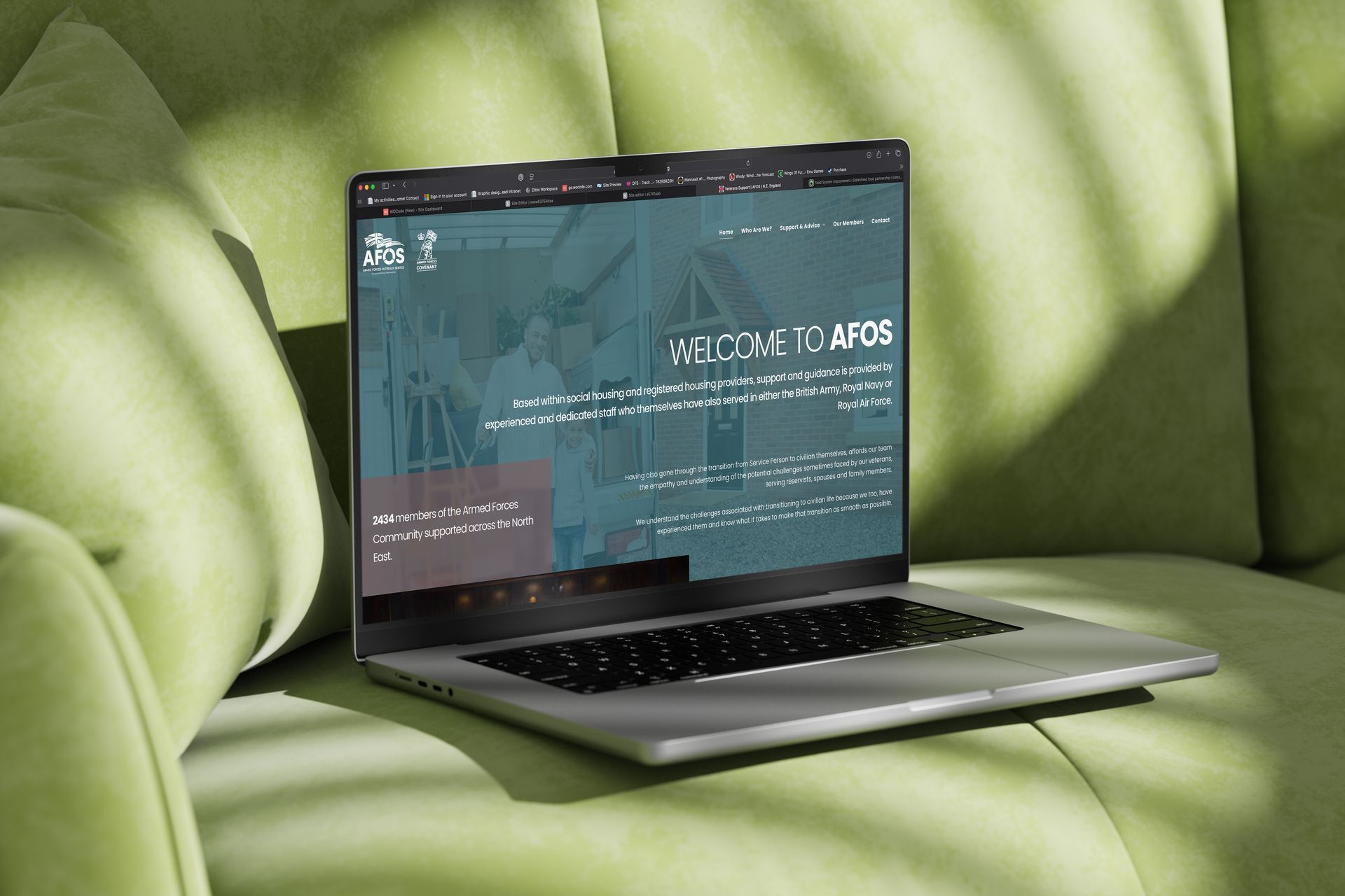 Laptop displaying a website, resting on a green couch.