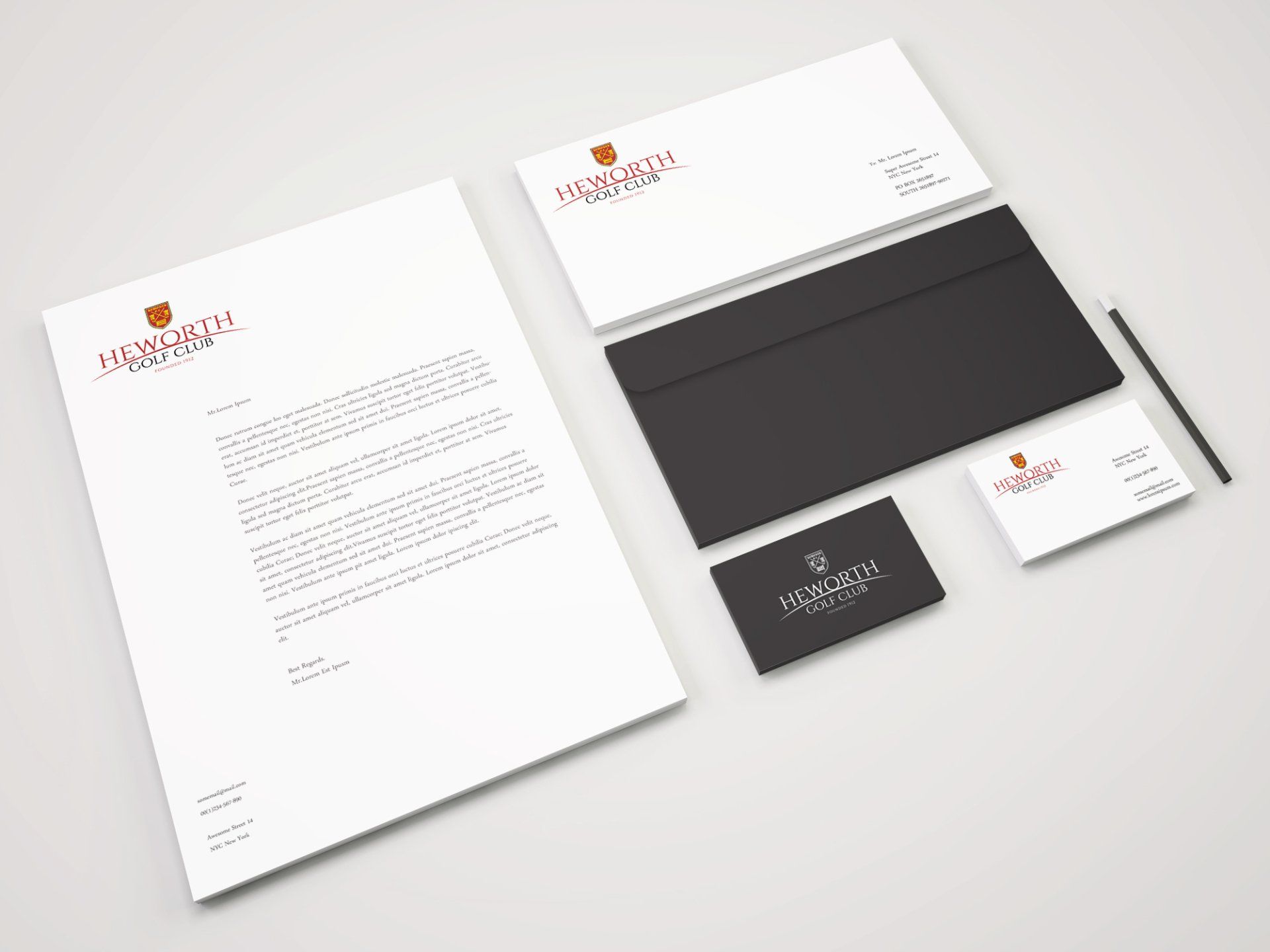 Stationery set with logo: letterhead, envelopes, business card, black envelope, and a pen.