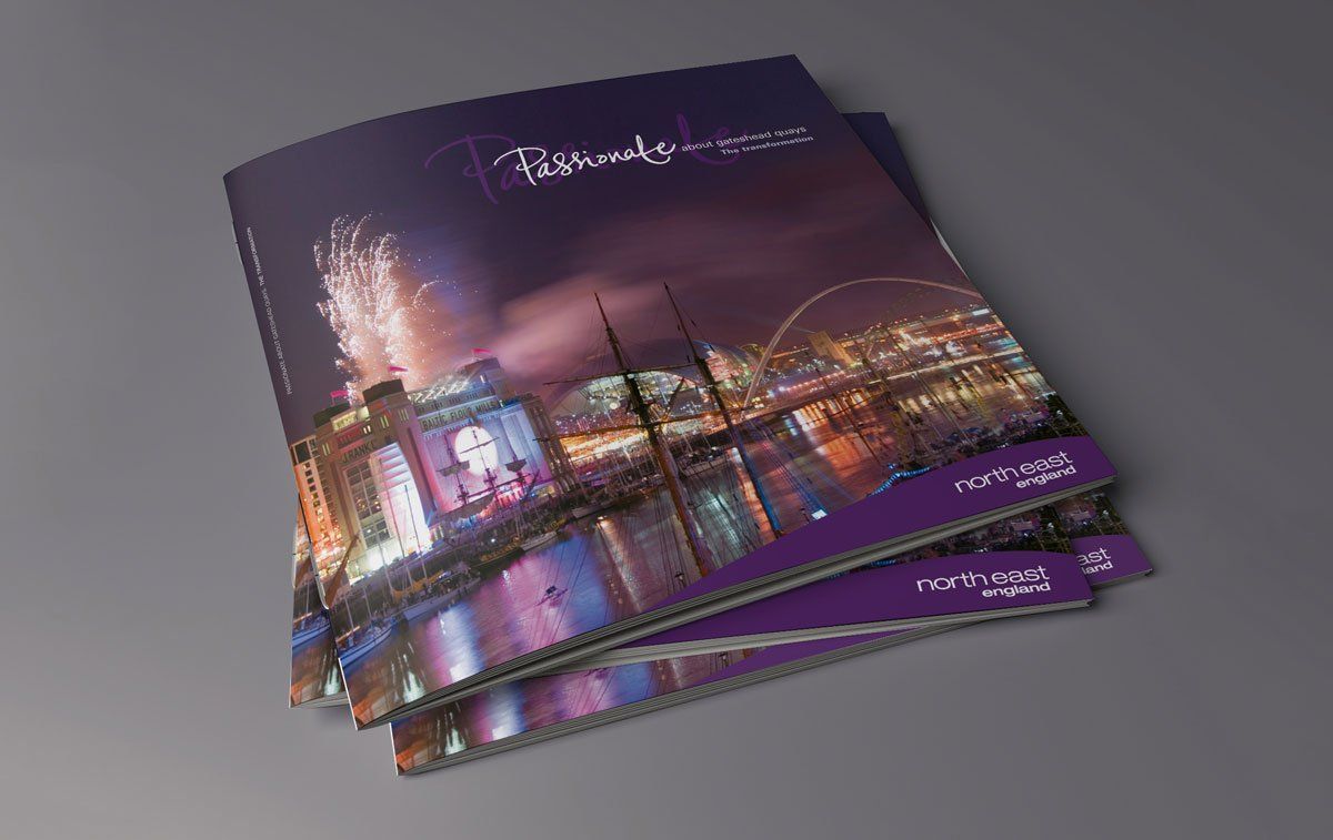 Brochures stacked, featuring a city skyline at night with fireworks, dark purple and bright lights.