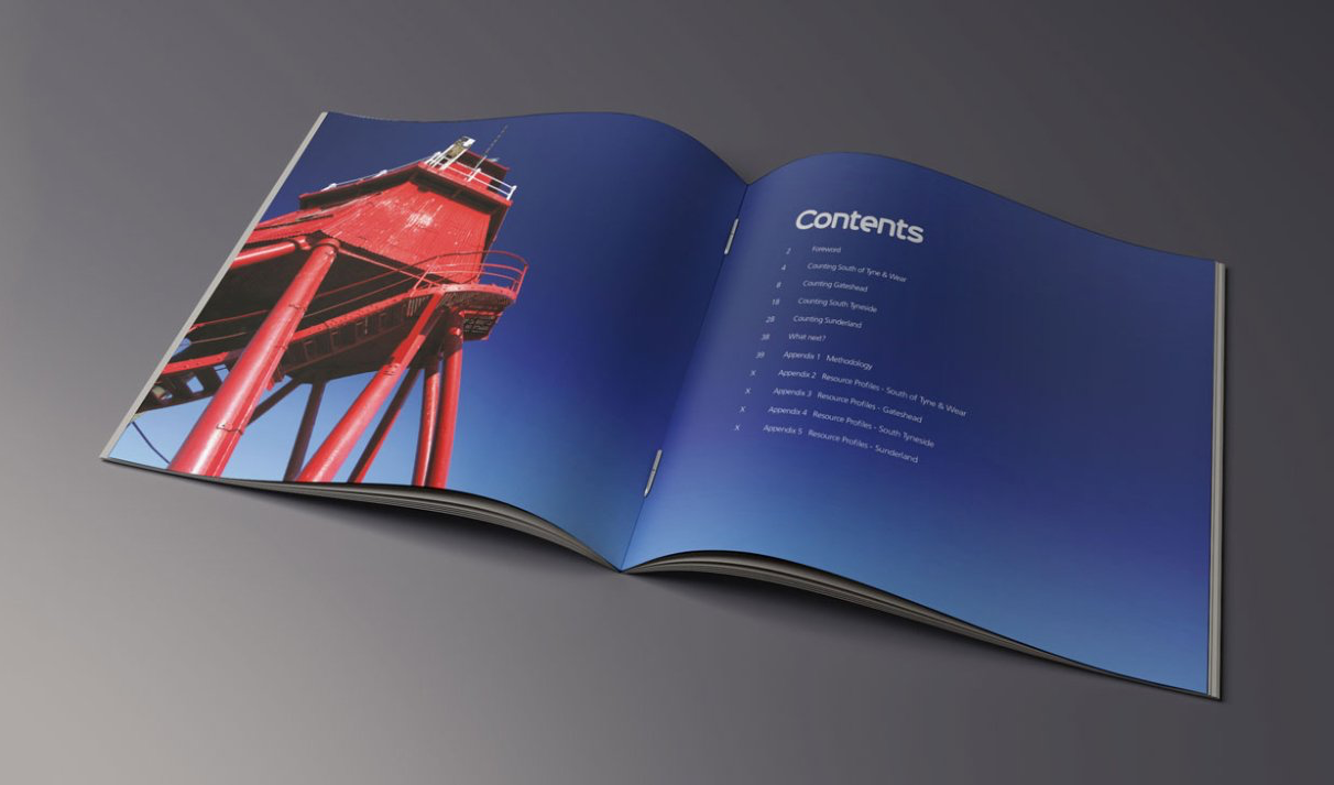 Open brochure with a photo of a red structure against a blue sky, facing text on the right.