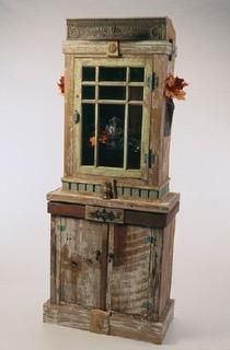 A wooden cabinet with a window on top of a wooden table.
