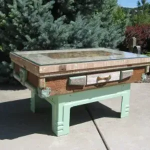 A coffee table made out of a suitcase is sitting on a sidewalk.