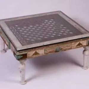 A wooden coffee table with a glass top is sitting on a white surface.