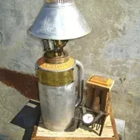 A lamp is sitting on top of a wooden table next to a clock.