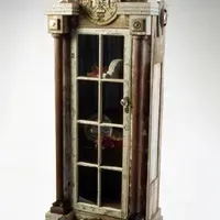 A wooden cabinet with a glass door and columns on a white background.