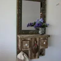 A mirror is hanging on a wall next to a shelf with drawers.