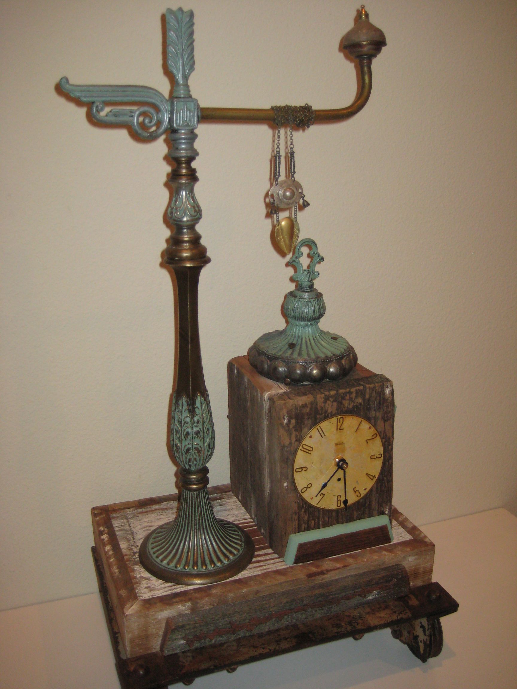 A clock is sitting on top of a wooden table next to a lamp.