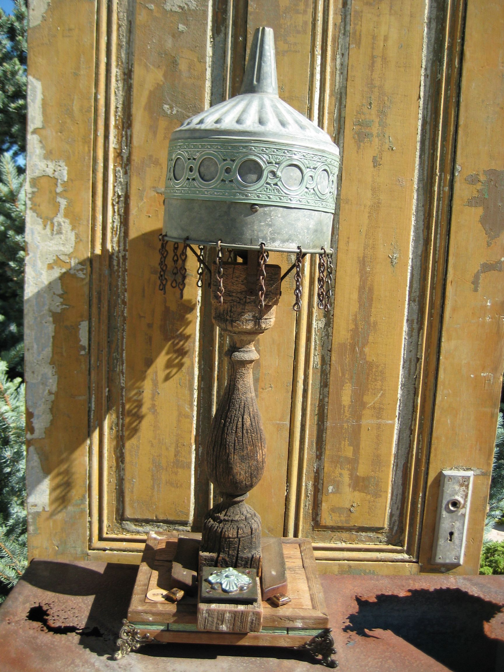 A lamp is sitting in front of a wooden door.