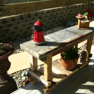 A wooden bench with potted plants and a red fire hydrant on top