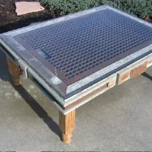 A coffee table with a solar panel on top of it.