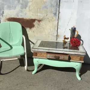 A green chair is sitting next to a green coffee table.