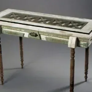 A wooden table with a glass top and drawers on a gray surface.