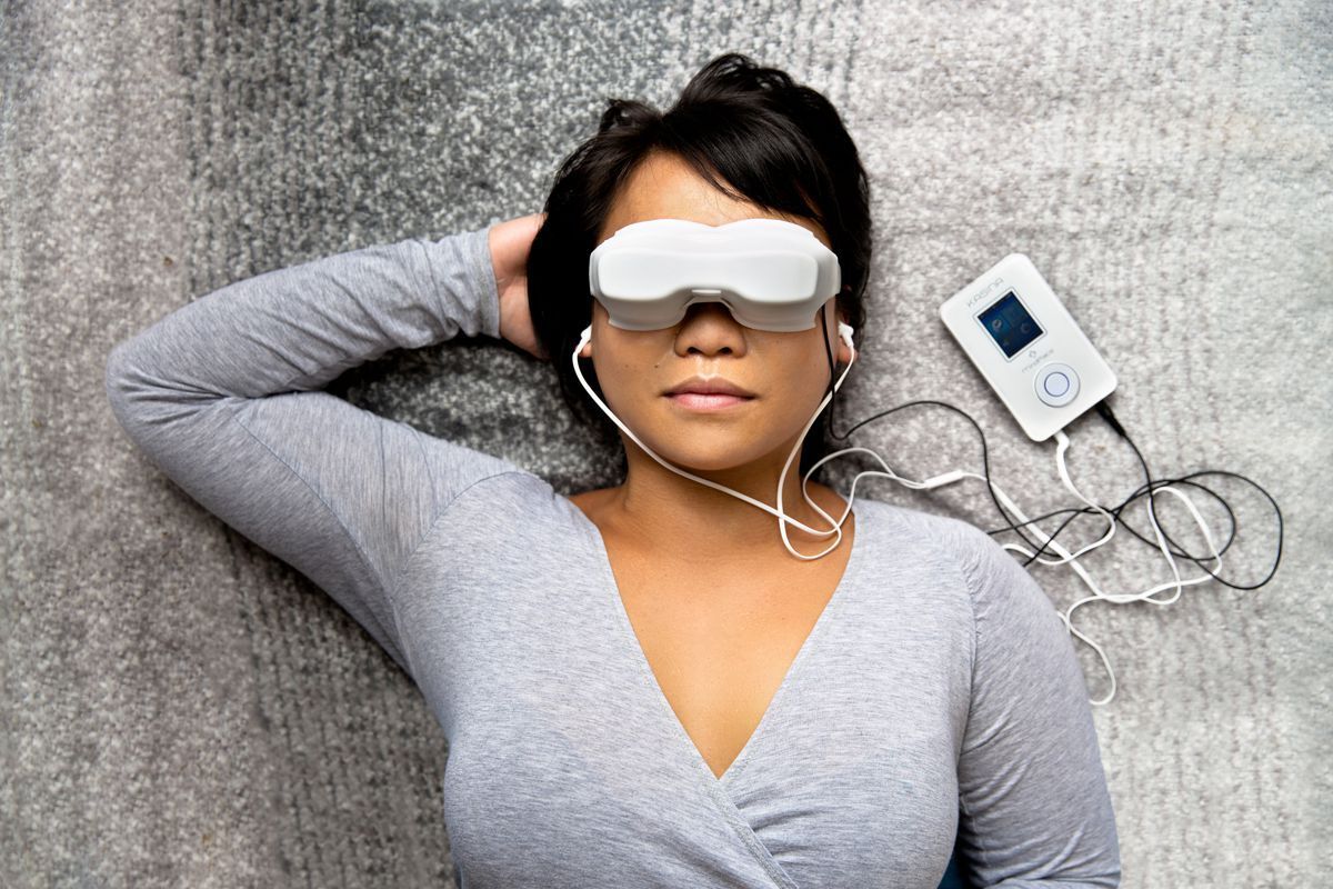 A woman is laying on the floor wearing a virtual reality headset.