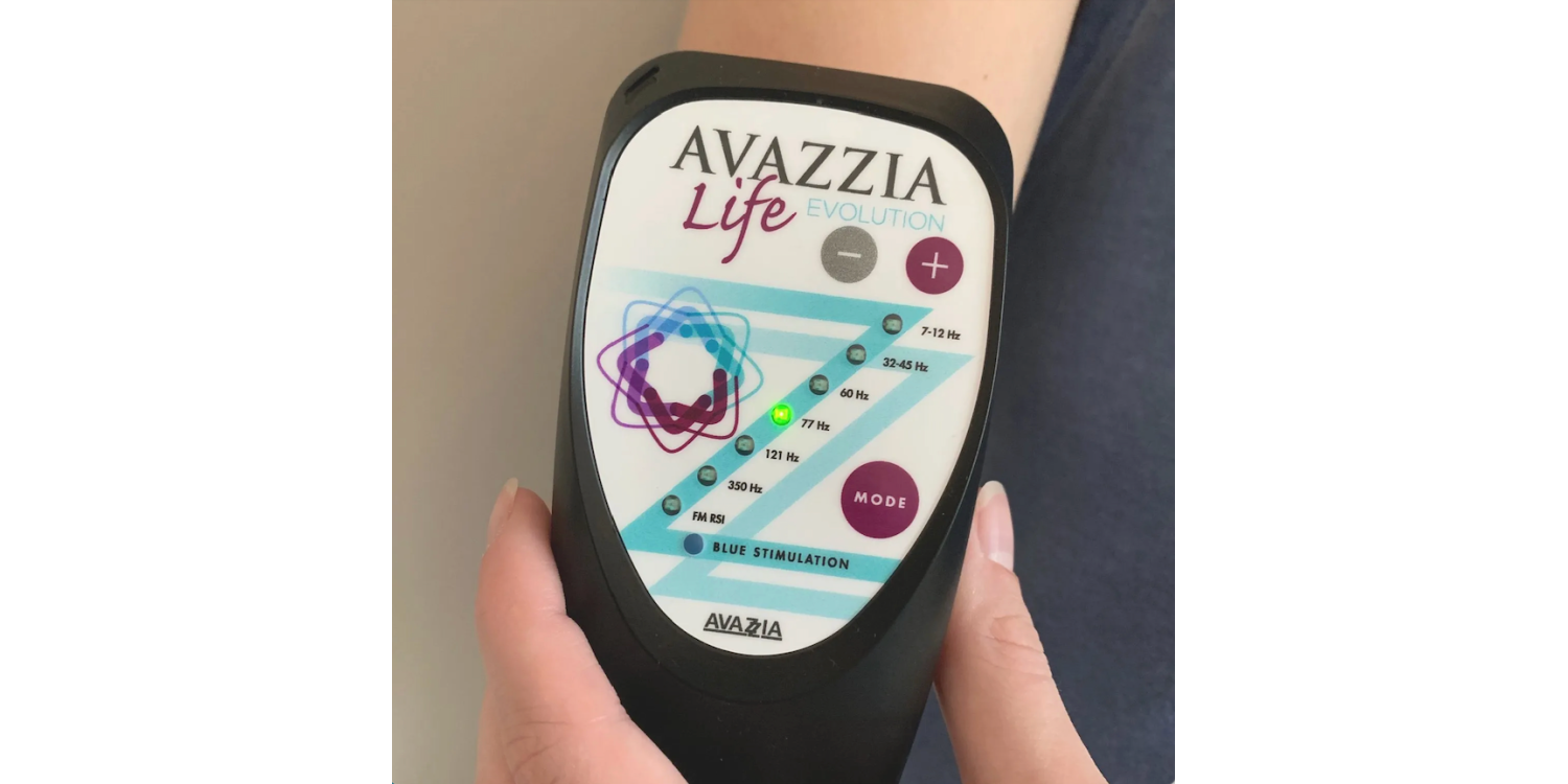 A person is holding an avazzia life device on their wrist.