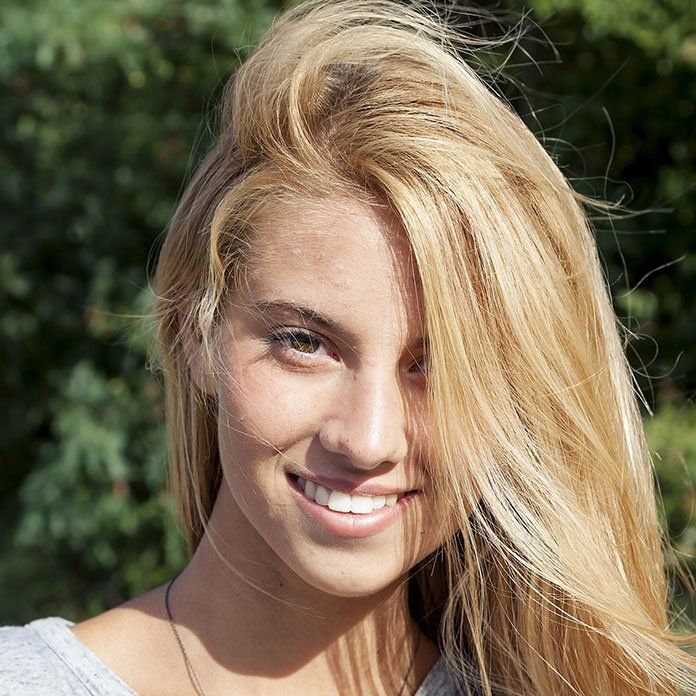 A woman with long blonde hair is smiling for the camera