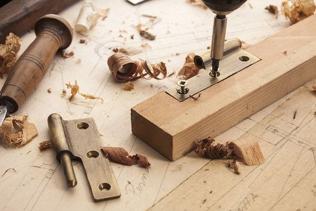 A drill is sitting on top of a piece of wood