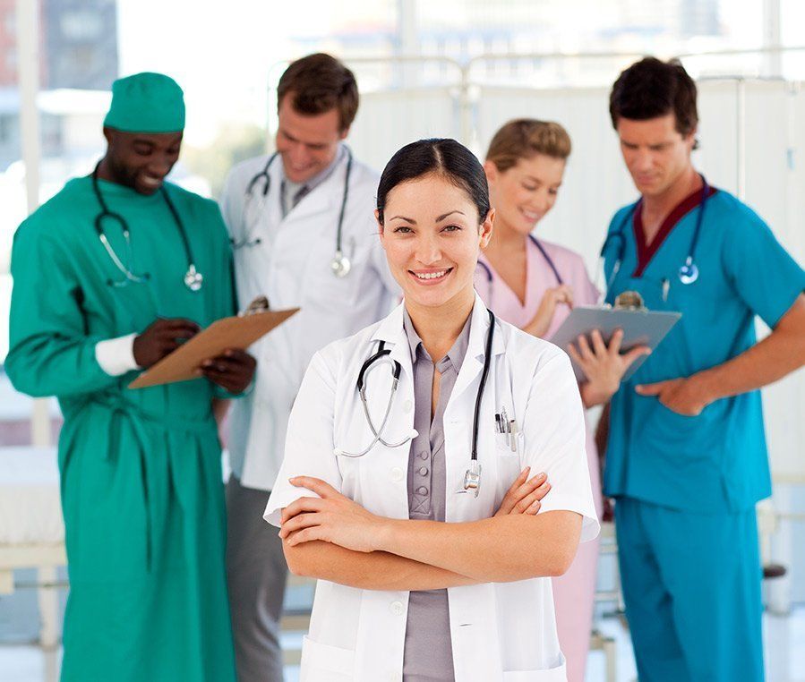 A group of doctors and nurses are posing for a picture