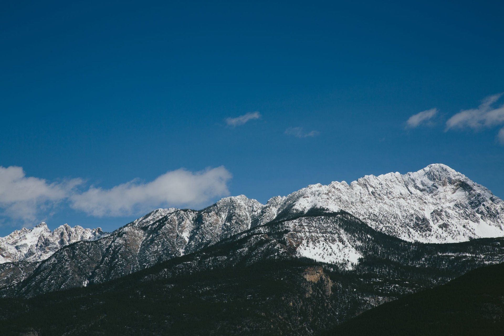 A snowy mountain range with a blue sky in the background