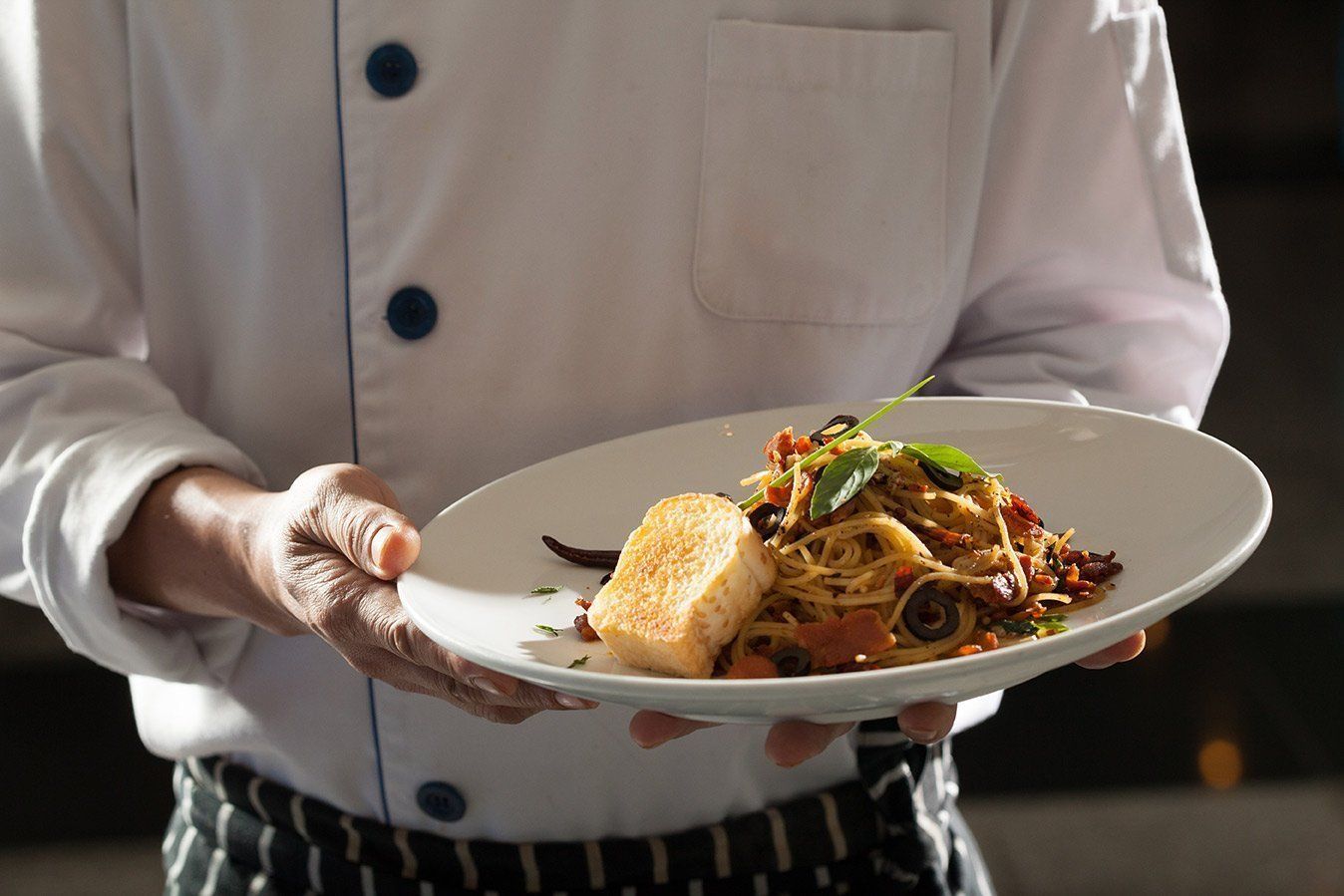 A chef holding a plate of food