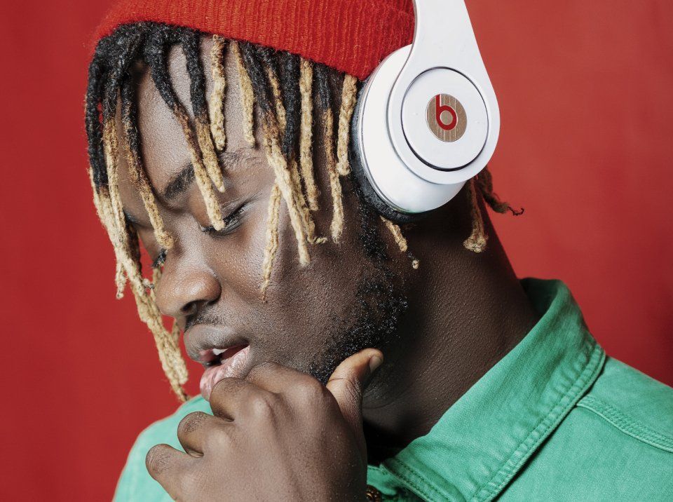 A man wearing a red hat and white beats headphones