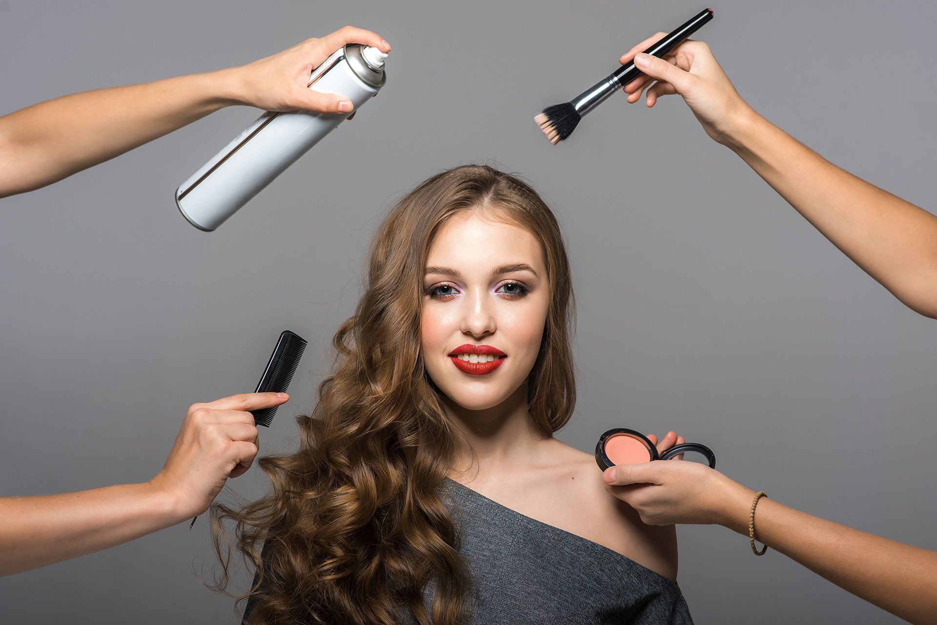A woman receiving hair and makeup assistance from other women at Mokara Solutions, specializing in hair and skin wellness.

