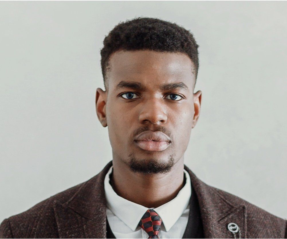 A man in a suit and tie is looking at the camera.