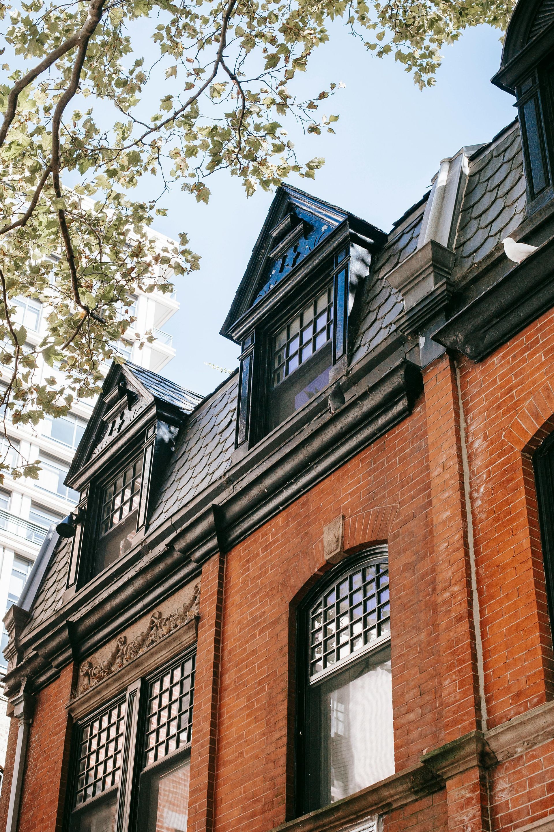 A brick building with a blue roof and a lot of windows.