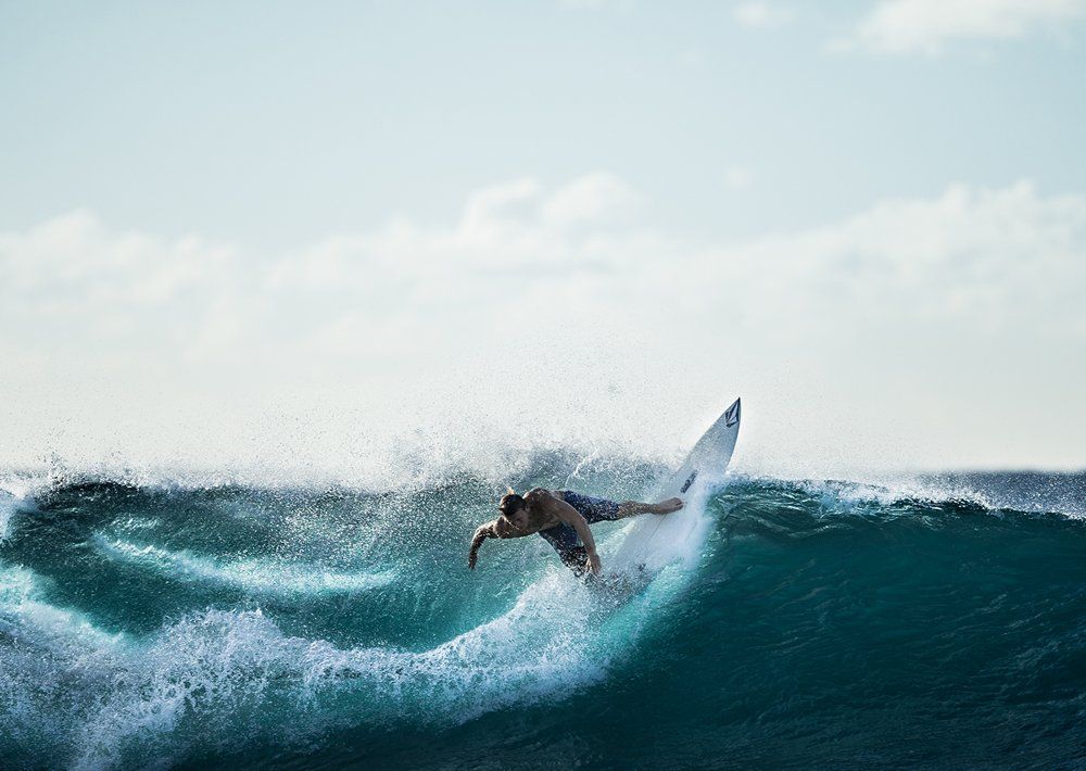 A man is riding a wave on a surfboard in the ocean.