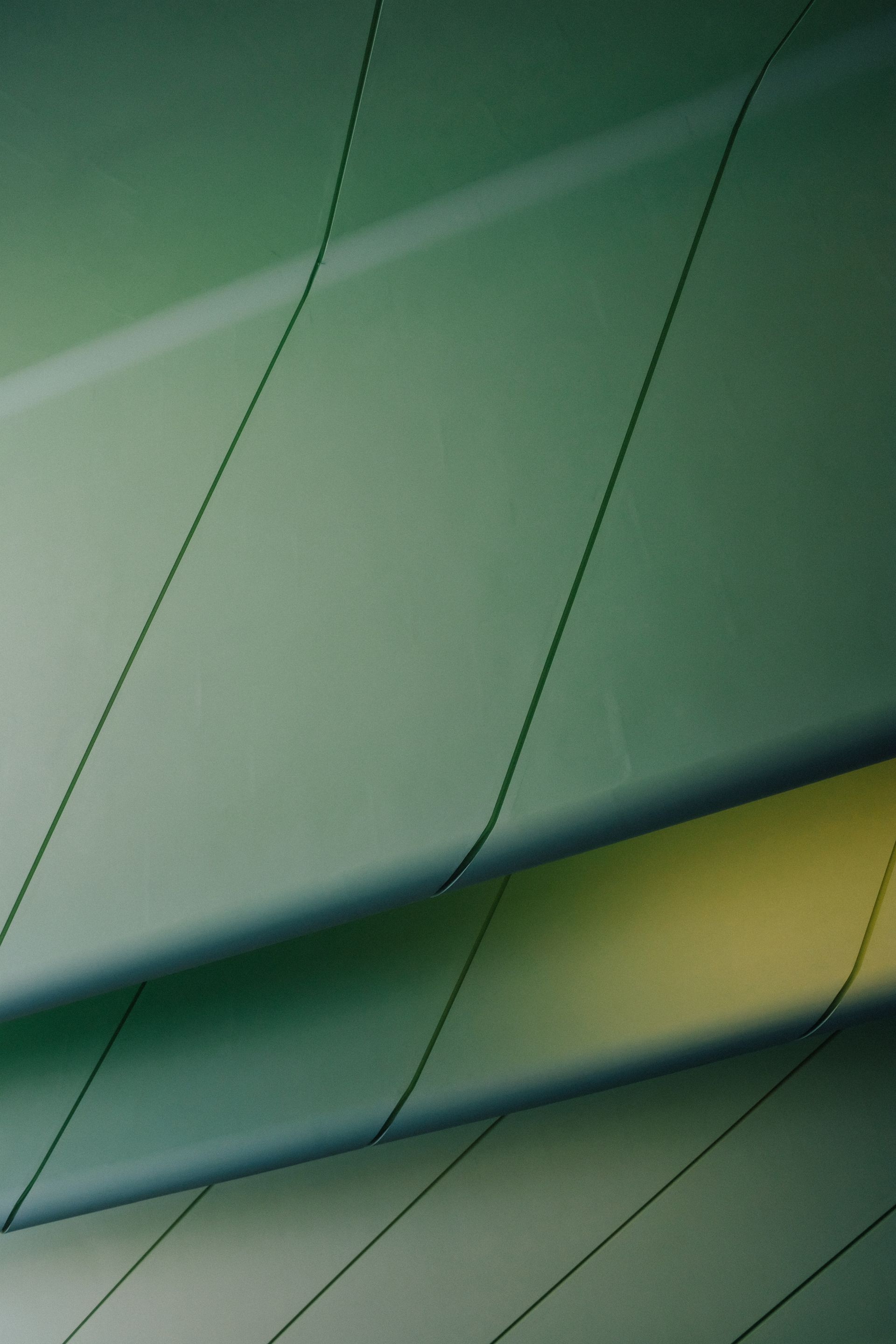 Overlapping green and yellow surfaces with diagonal black lines.