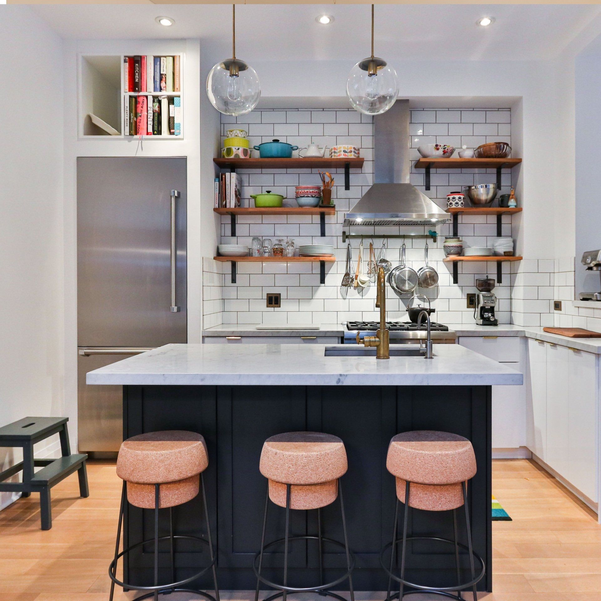 A kitchen with a large island and three stools
