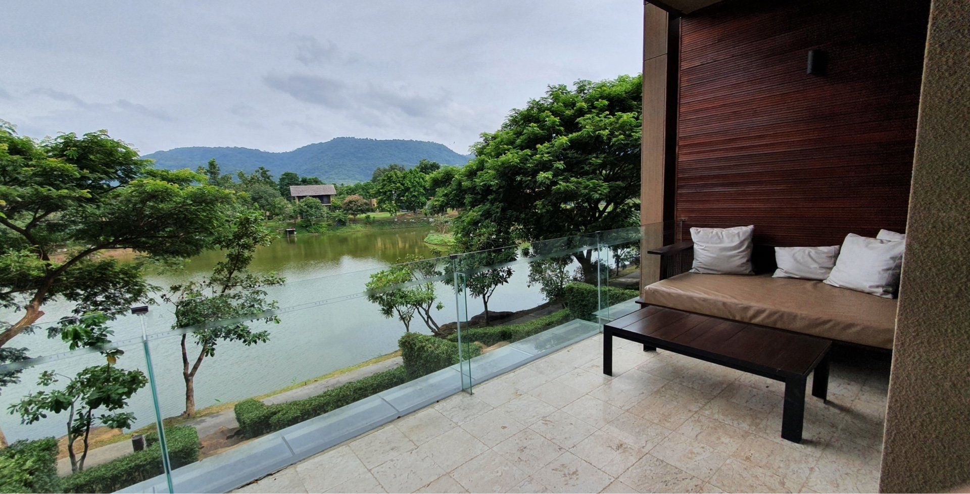 A balcony with a couch and a view of a lake.