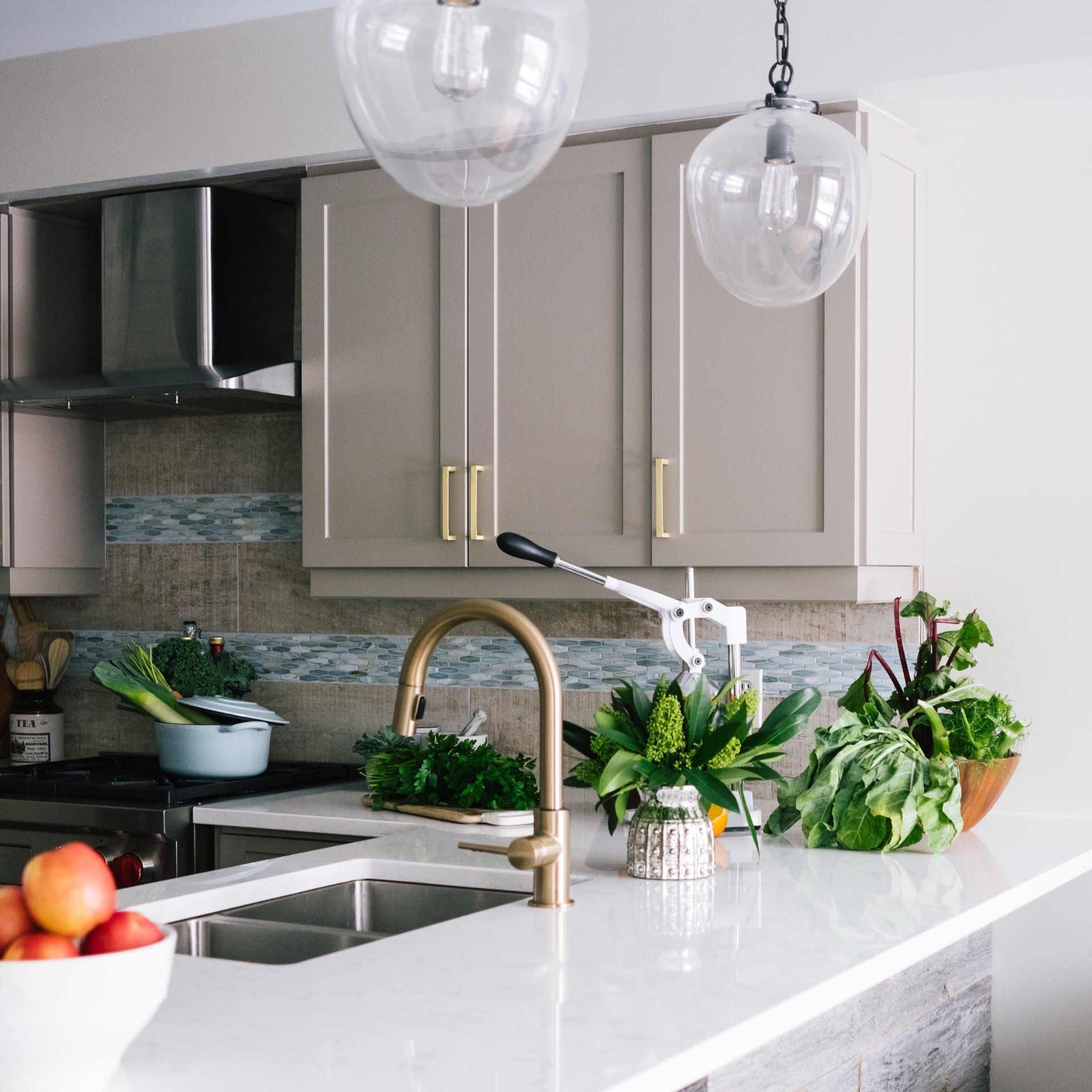 A kitchen with a sink and a bowl of fruit on the counter